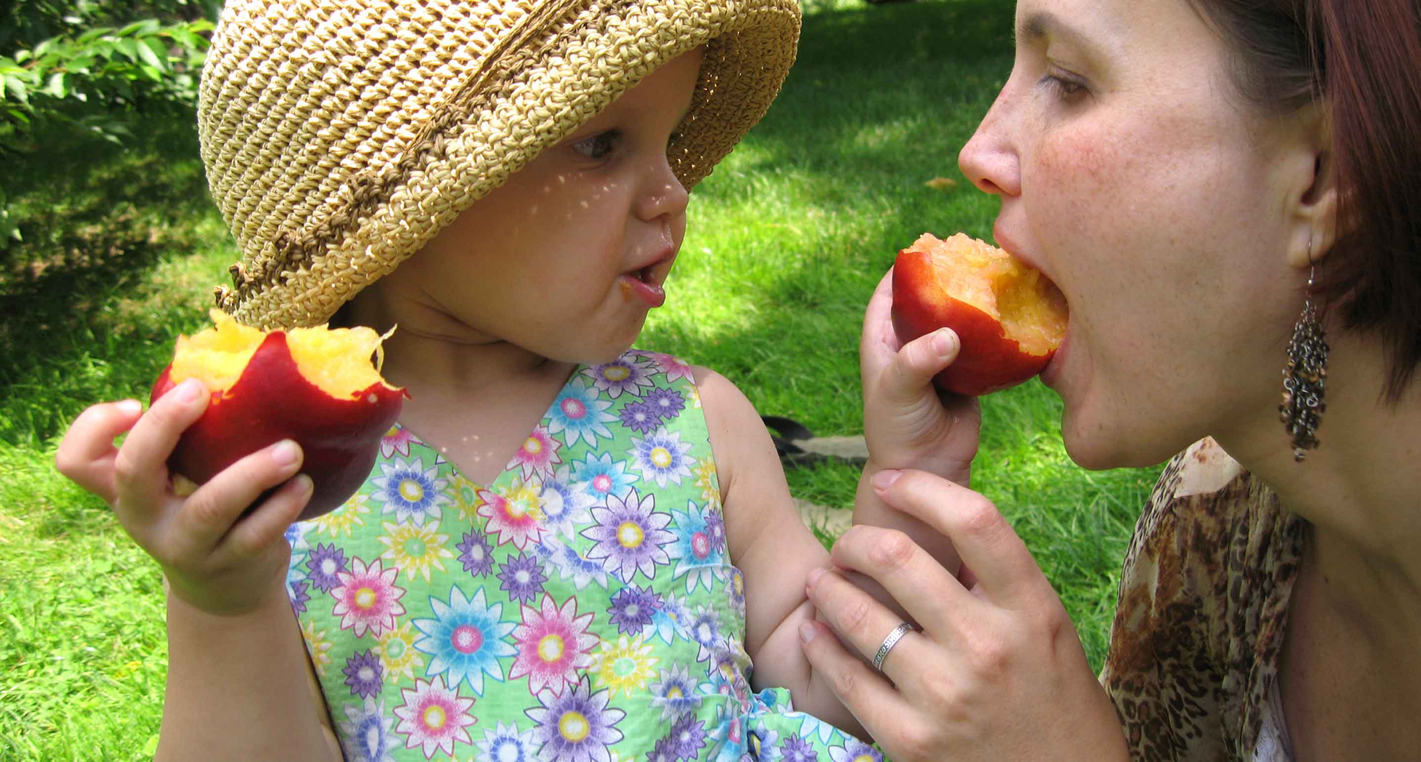 little girl feeding peaches to her mother